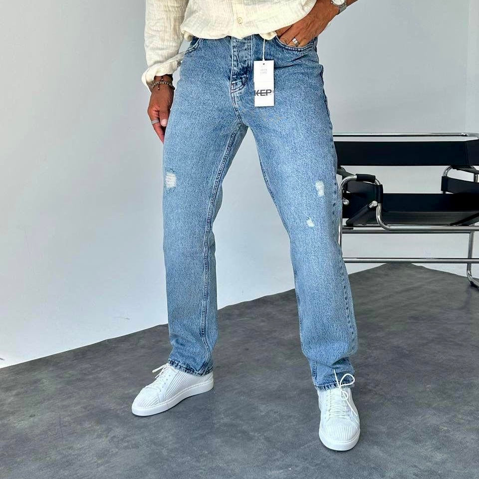 Man draagt lichtblauwe straight leg jeans met distressed details – Streetfashion86
